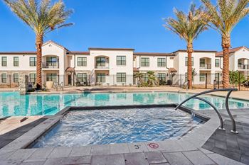a swimming pool with palm trees and apartments in the background at Stella Luxury Apartment Homes, San Tan Valley, AZ, 85143